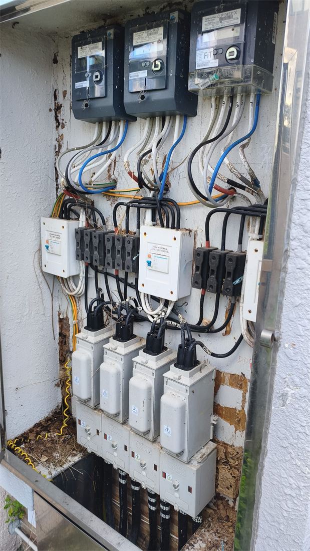 打開的村屋三相電錶箱，三個電錶、多組保險絲座及刀掣